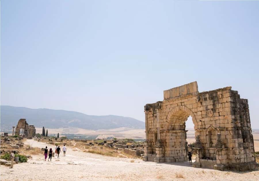 From Fez: Volubilis, Moulay Idriss and Meknes Full Day Tour - Walking through the Roman remains at Volubilis